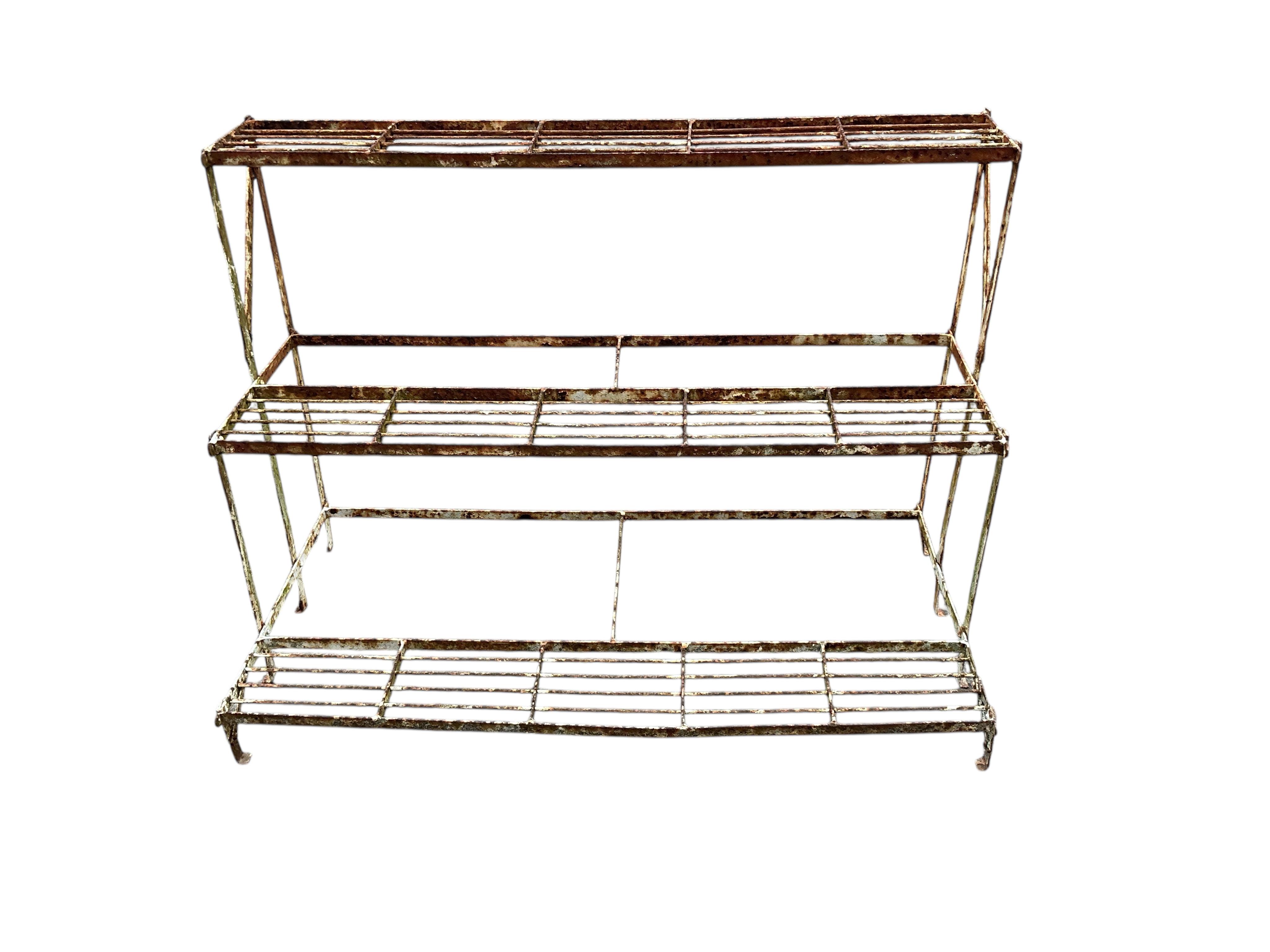 A painted wrought iron three tier pot stand, width 100cm, depth 50cm, height 73cm
